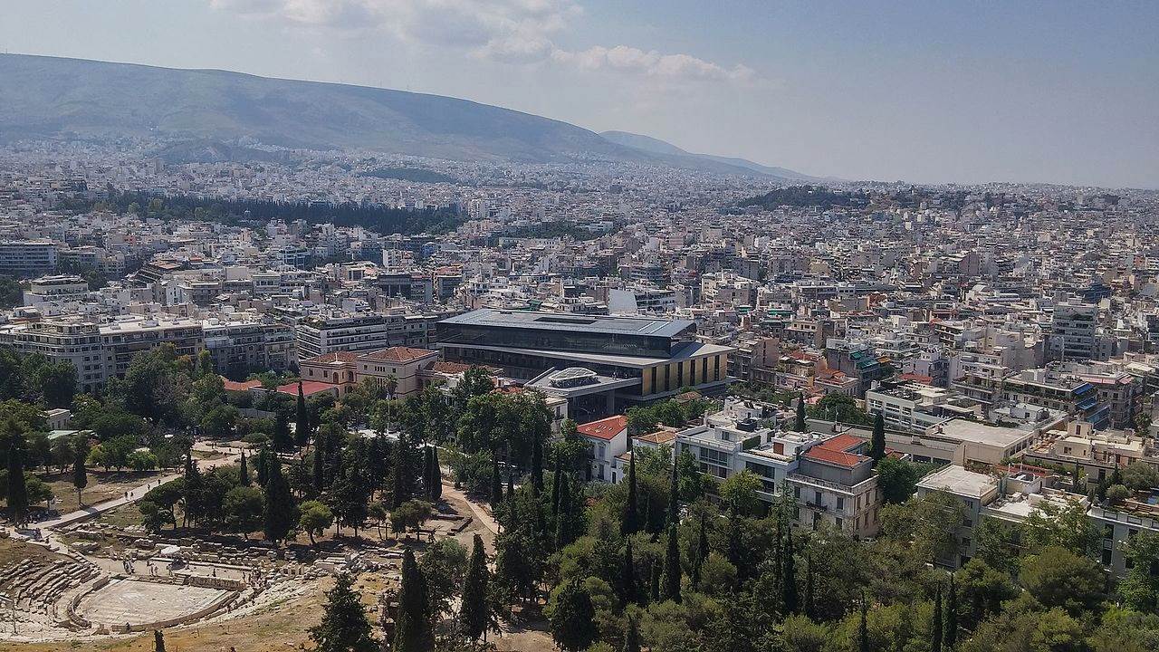 View from the Acropolis in Athens with Theatre of Dionysus Eleuthereus, Acropolis Museum, and city towards the horizon, 2017